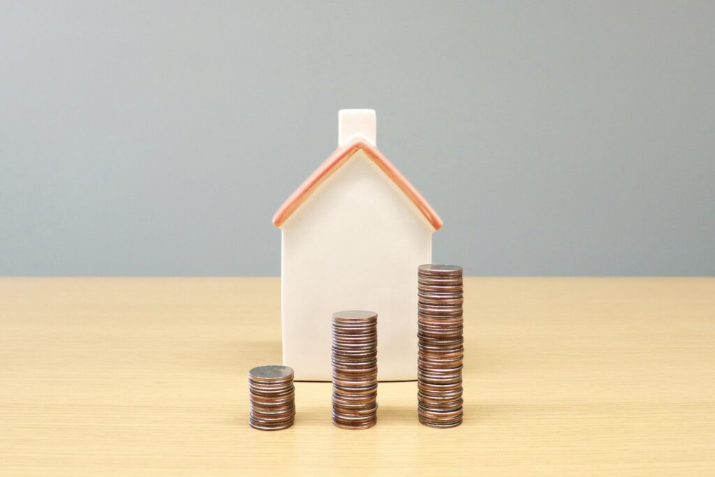 a house and stacks of coins on a table